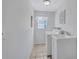 Bright laundry room with a white washer, dryer, utility sink, and neutral tile flooring at 1487 Dundee Dr, Palm Harbor, FL 34684