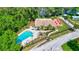 Aerial view of a community swimming pool with lounge chairs, picnic area, and lush greenery at 1487 Dundee Dr, Palm Harbor, FL 34684