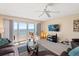 Bright living room featuring a ceiling fan and sliding doors leading to a patio with beach view at 17200 Gulf Blvd # 302, North Redington Beach, FL 33708