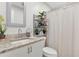 Bathroom featuring granite countertops, mirror, and a shower with curtain at 1721 S Jefferson Ave, Clearwater, FL 33756