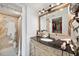 Well-lit bathroom featuring a vanity with a granite countertop, decorative mirror, and shower with decorative tile surround at 201 W Laurel St # 909, Tampa, FL 33602