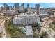 Picturesque view of the condo building amidst lush trees, a pool, and a vibrant city skyline in the background at 201 W Laurel St # 909, Tampa, FL 33602