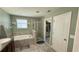 Bathroom features a soaking tub, separate shower, and a door leading to a walk-in closet at 21211 Southern Charm Dr, Land O Lakes, FL 34637