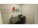 Modern laundry room with gray front load washer and dryer and wire shelving at 21211 Southern Charm Dr, Land O Lakes, FL 34637