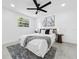 Bedroom with a ceiling fan, grey rug, and large window providing natural light at 2522 W North St, Tampa, FL 33614