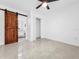 Bedroom featuring a barn door leading to an ensuite bathroom and sleek flooring at 2522 W North St, Tampa, FL 33614