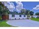 Single-story home with a large driveway, fresh white paint, and a newly installed wooden fence and landscaping at 2522 W North St, Tampa, FL 33614