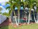 Backyard featuring a screened pool, with palms and white fence, offering a tropical and private outdoor space at 3600 105Th N Ave, Clearwater, FL 33762