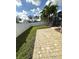 Backyard view with patio pavers, grass, palms, and fence, that provides ample space for outdoor activities at 3600 105Th N Ave, Clearwater, FL 33762