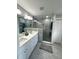 Well-lit bathroom featuring double sinks and a sleek, glass-enclosed shower at 3600 105Th N Ave, Clearwater, FL 33762