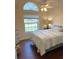 Cozy bedroom with hardwood flooring, an arched window and a ceiling fan at 3600 105Th N Ave, Clearwater, FL 33762