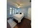 Comfortable bedroom featuring a ceiling fan, wood floors, and soft, natural light from the three windows at 3600 105Th N Ave, Clearwater, FL 33762