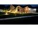 Night view of home's exterior elevation with professional lighting and manicured lawn at 3600 105Th N Ave, Clearwater, FL 33762