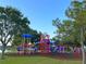 Community playground area with swings, climbing structure, slides, and mature trees at 3600 105Th N Ave, Clearwater, FL 33762