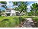 Townhome backyard featuring covered patio, balcony, lush lawn, and sidewalk at 5095 San Martino Dr, Wesley Chapel, FL 33543