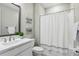 Well-lit bathroom featuring a modern vanity, toilet, and a shower-tub combination with a stylish shower curtain at 5095 San Martino Dr, Wesley Chapel, FL 33543