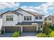 Beautiful two-story home showcasing a tandem three-car garage, paver driveway, white stucco, and dark trim at 5095 San Martino Dr, Wesley Chapel, FL 33543