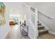 Bright hallway features wood-look floors leading to a sunlit living room with a staircase to the upper level at 5095 San Martino Dr, Wesley Chapel, FL 33543