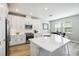 Bright kitchen with white cabinets, stainless steel appliances, a large island with seating, and wood-look tile flooring at 5095 San Martino Dr, Wesley Chapel, FL 33543