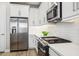 Stylish kitchen featuring white cabinets, stainless steel appliances, a subway tile backsplash, and white countertops at 5095 San Martino Dr, Wesley Chapel, FL 33543