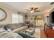 Comfortable living room with an oversized sofa, wood floors, a ceiling fan, and sliding doors leading to the screened porch at 515 Mistletoe Ct # C, Safety Harbor, FL 34695