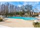 Community pool with a lot of lounge chairs and a view of tall trees and the building at 515 Mistletoe Ct # C, Safety Harbor, FL 34695