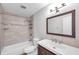 Updated bathroom with tiled shower-tub, wood vanity, and modern fixtures at 5152 Salmon Se Dr # C, St Petersburg, FL 33705