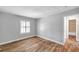 Bright bedroom featuring wood-look floors, a window with white shutters, and neutral walls at 5152 Salmon Se Dr # C, St Petersburg, FL 33705