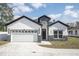 The exterior elevation of the home shows off the two-car garage and stone facade accents at 5351 71St N Way, St Petersburg, FL 33709