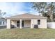 An exterior view of a house showcasing the backyard with a covered patio and a built-in barbecue grill at 5361 71St N Way, St Petersburg, FL 33709