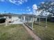 Backyard featuring green grass, a small patio, and a trellis structure at 540 Florida S Cir, Apollo Beach, FL 33572