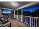 Cozy covered balcony with comfortable seating, offering a relaxing view of the pool and the sunset at 614 Maryland Ave, Crystal Beach, FL 34681