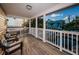 Lovely covered porch with seating overlooking tropical landscaping, swimming pool, and ocean at 614 Maryland Ave, Crystal Beach, FL 34681