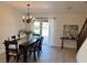 Bright dining room with a chandelier and a view of the pool through sliding glass doors at 614 Maryland Ave, Crystal Beach, FL 34681