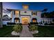 Stately home with a welcoming entryway, featuring blue shutters, a charming walkway, and lush landscaping at 614 Maryland Ave, Crystal Beach, FL 34681