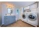 Functional laundry room with tile flooring, blue cabinetry and stacked washer and dryer at 614 Maryland Ave, Crystal Beach, FL 34681