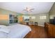 Spacious bedroom featuring a ceiling fan, hardwood floors, and multiple windows with sunset views at 614 Maryland Ave, Crystal Beach, FL 34681