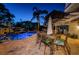 A backyard pool has an umbrella-covered dining set next to the pool at 614 Maryland Ave, Crystal Beach, FL 34681