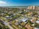 Picturesque aerial view of a coastal neighborhood with mature trees and a high rise condominium on the beach at 66 Kipling Plz, Clearwater Beach, FL 33767