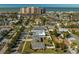 Sweeping aerial view of a neighborhood near the beach with lush landscaping and high rise condos in the distance at 66 Kipling Plz, Clearwater Beach, FL 33767