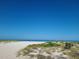 Tranquil beach scene with white sand dunes and natural vegetation under a clear blue sky at 66 Kipling Plz, Clearwater Beach, FL 33767