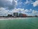 Expansive beach view with clear water, numerous beachgoers, and towering buildings in the distance at 66 Kipling Plz, Clearwater Beach, FL 33767