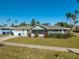 Charming single-story home with a well-manicured lawn and a red front door at 66 Kipling Plz, Clearwater Beach, FL 33767