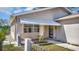 A quaint covered front porch with decorative railing and security gate provides a welcoming entrance at 7048 68Th N St, Pinellas Park, FL 33781