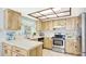 Well-lit kitchen featuring stainless steel appliances, plenty of counter space, and light wood cabinets at 7048 68Th N St, Pinellas Park, FL 33781