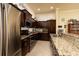 A kitchen features dark wood cabinetry with granite countertops and stainless steel appliances at 707 Highland N St, St Petersburg, FL 33701