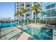 Rooftop hot tub and community pool offer a relaxing retreat with building views and palm trees at 777 N Ashley Dr # 1505, Tampa, FL 33602