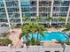 Luxury building featuring a rooftop pool, palm trees, and numerous sun loungers at 777 N Ashley Dr # 1505, Tampa, FL 33602