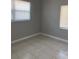 Bedroom featuring tile flooring, window and neutral paint at 7908 Rideout Rd, Tampa, FL 33619