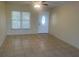 Bright living room featuring neutral paint, tile flooring, ceiling fan and a front door with decorative glass at 8969 109Th Ter, Seminole, FL 33777